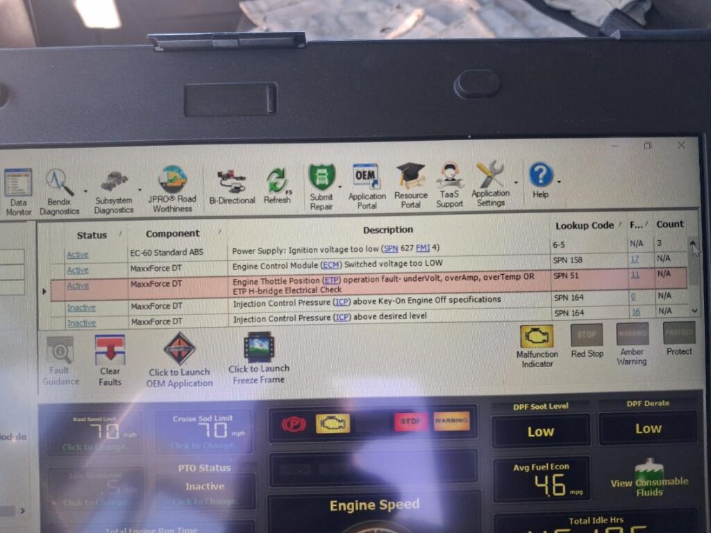 Laptop screen displaying professional JPRO diagnostic software for a MaxxForce DT engine with active SPN fault codes.