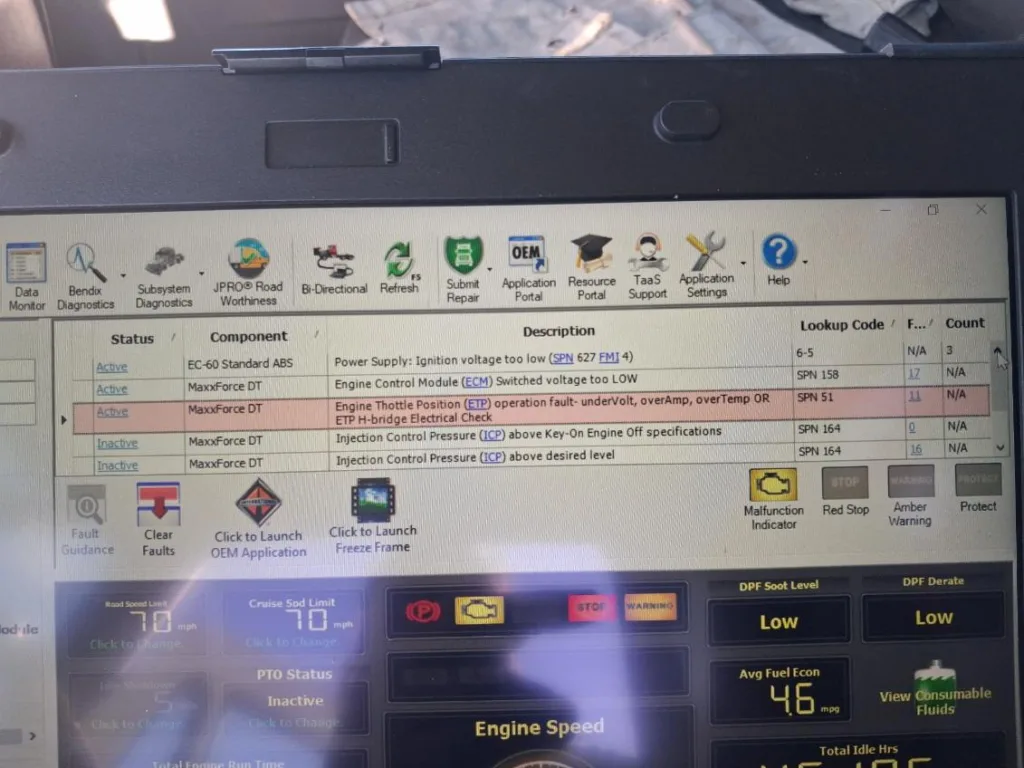 Laptop screen displaying professional JPRO diagnostic software for a MaxxForce DT engine with active SPN fault codes.