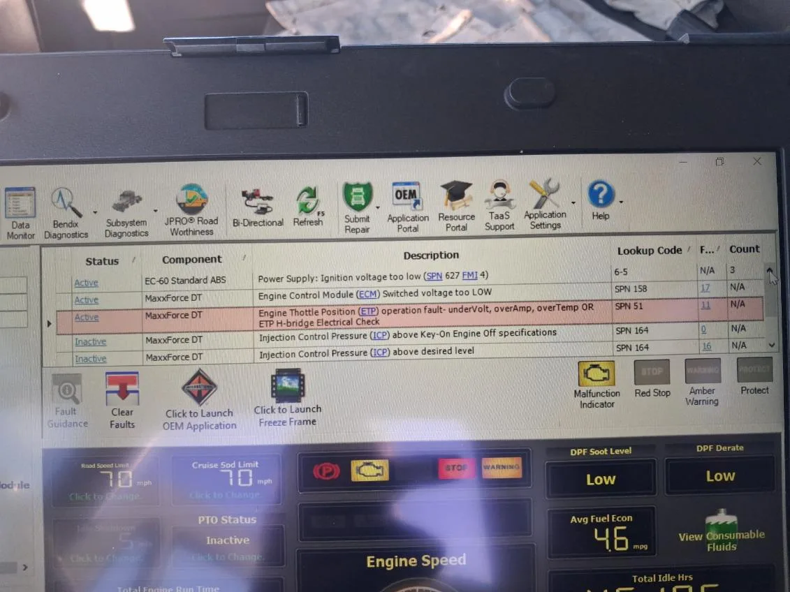Laptop screen displaying professional JPRO diagnostic software for a MaxxForce DT engine with active SPN fault codes.